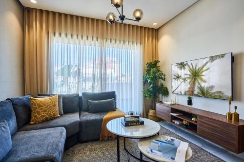 un salon avec un canapé et une télévision dans l'établissement Sleek and Modern 2-Bed Unit in Downtown Casa, à Casablanca