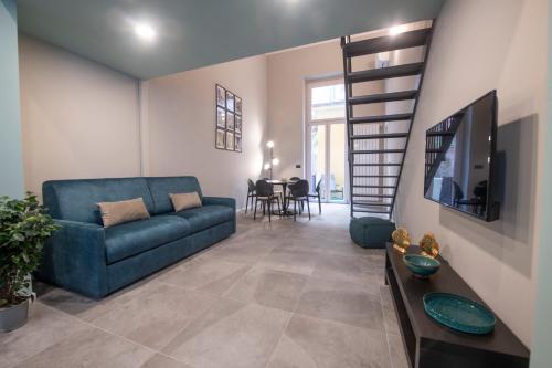 un soggiorno con divano blu e TV di 227 - Largo Zecca Luxury Apartment - Nel cuore del centro di Genova a Genova