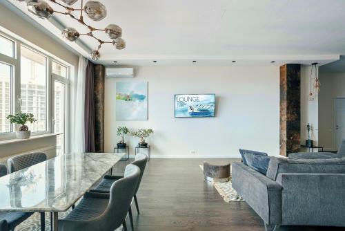 a dining room with a glass table and chairs at Odesa Pearl Apartments in Odesa