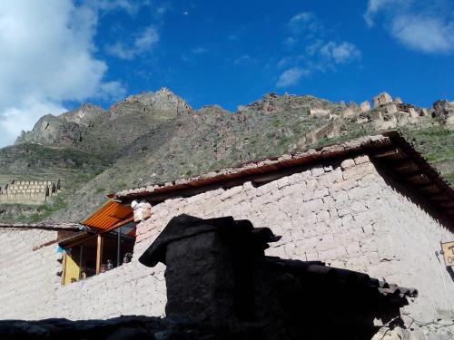 a stone building with a mountain in the background at B&B Chayana Wasi in Ollantaytambo
