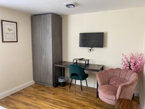 a room with a desk and a chair and a television at Silk Hotel in Boston