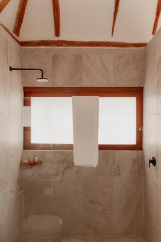 a bathroom with a shower and a window at Prana Boutique Hotel Tulum in Tulum
