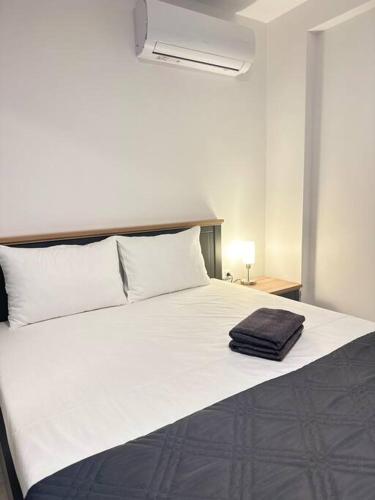 - un grand lit blanc avec une serviette noire dans l'établissement DA apartments, à Varna