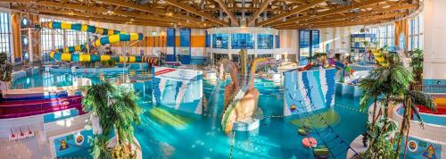 a large indoor swimming pool with a water park at Bianco Apartament Reduta Park Free Parking in Kraków