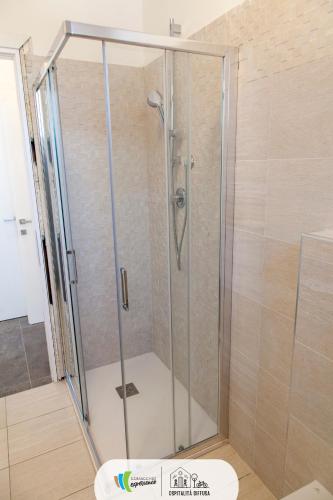 a shower with a glass door in a bathroom at Comacchio Experience - Ospitalità Diffusa in Lido di Pomposa