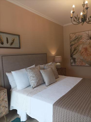 1 dormitorio con 1 cama con sábanas y almohadas blancas en Betalia, en Caldas de Reis