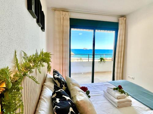 a bedroom with a couch and a view of the beach at Paradise Home By Gloove in Villajoyosa