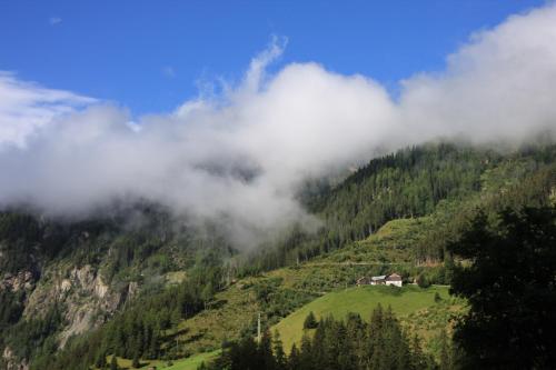 a misty mountain with a house in the middle at Ferienwohnung Moritz in Kaunertal