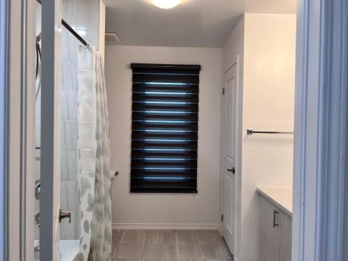 a bathroom with a shower and a black window at Spacious 4-Bedroom Home, Comfortably Sleeps 10 in Barrie