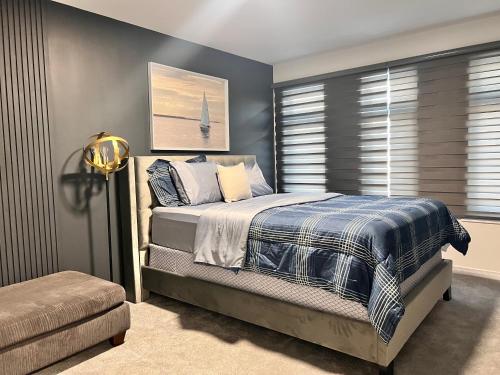 1 dormitorio con 1 cama con pared azul en Spacious 4-Bedroom Home, Comfortably Sleeps 10 en Barrie