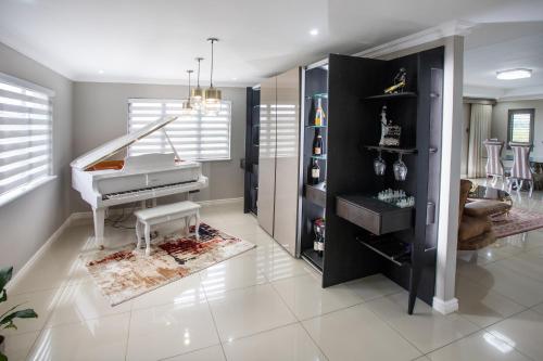 a living room with a white piano in a room at Luxury Countryside Gataway Hillcrest in Hillcrest