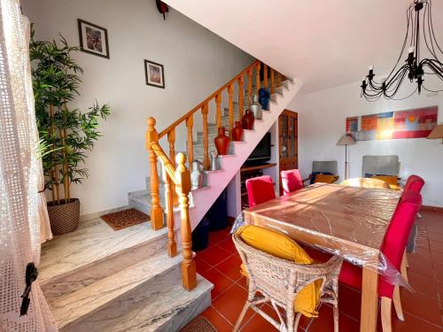 a dining room with a table and a staircase at Casa da Horta in Canha