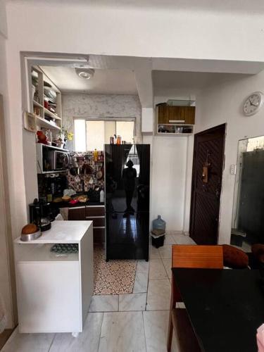 a kitchen with a person standing in the middle of a room at Vem curtir na praia e na cidade. in Salvador