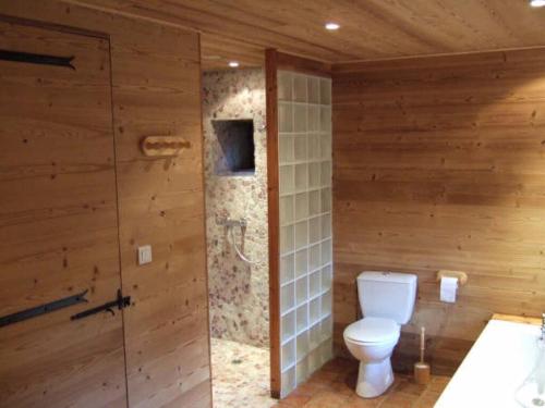 een badkamer met een toilet in een houten muur bij Nice apartment in Olsberg 