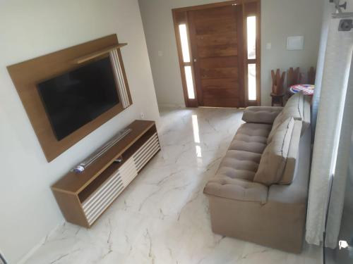 uma sala de estar com uma televisão de ecrã plano e um sofá em Novo Horizontes em São João del Rei