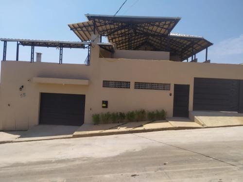 um edifício com duas portas de garagem e um telhado em Novo Horizontes em São João del Rei