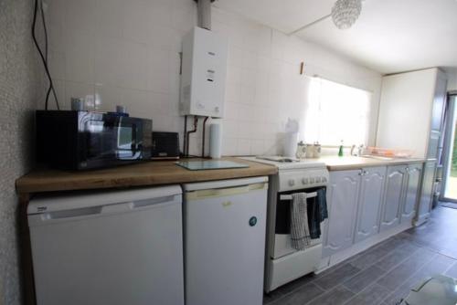 a kitchen with a counter top with a microwave at Beautiful Chalet close to the beach in Eastchurch