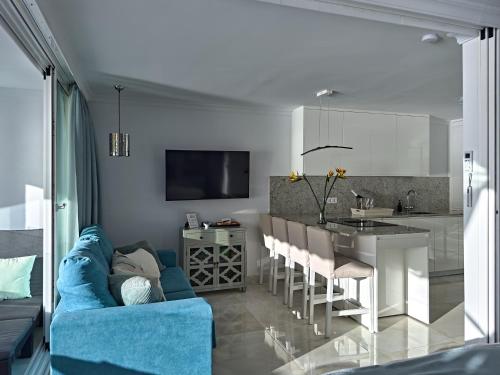 a living room with a blue couch and a kitchen at Doñana 1021 in Patalavaca