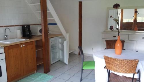 une cuisine avec une table et un évier, ainsi qu'un escalier. dans l'établissement Petite maison de charme, à Langres