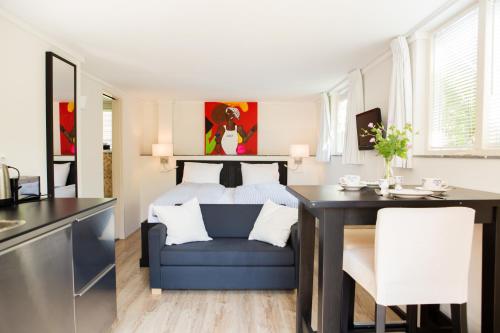 a bedroom with a blue chair and a dining room table at B & B Villa Suisse in Scheveningen