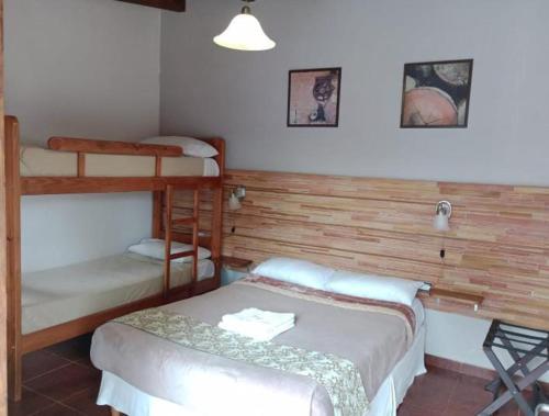 a bedroom with two bunk beds and a desk at Hostería Montes in San Ignacio