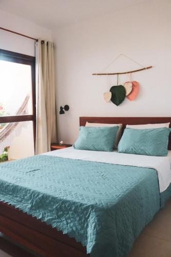 a bedroom with a bed with a blue comforter and a window at Pousada Casa de Hóspedes in Icaraí
