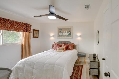 1 dormitorio con 1 cama blanca y ventilador de techo en Chic Bakersfield Apartment about 5 Mi to Downtown!, en Bakersfield