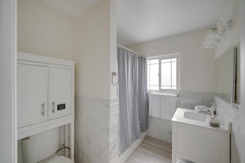 y baño blanco con lavabo y ducha. en Chic Bakersfield Apartment about 5 Mi to Downtown!, en Bakersfield