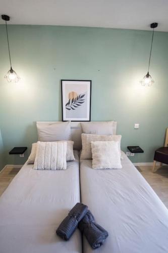 - une chambre avec 2 lits blancs avec des chaussures dans l'établissement Studio Au Sommet - clim - gare, à Lourdes