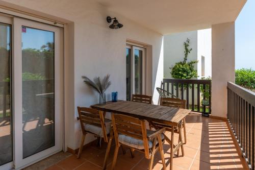 a wooden table and chairs on a balcony at Cozy beachfront 2BR with Terrace, Pool and Garage in Sitio de Calahonda