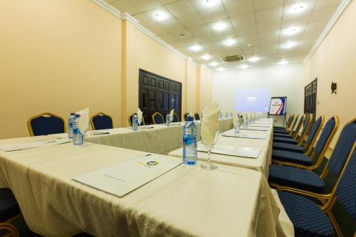 a row of tables in a room with chairs at Midindi Hotel in Accra