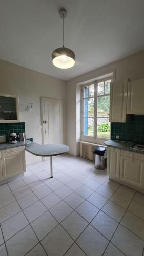 - une cuisine avec une table au milieu d'une pièce dans l'établissement Demeure d'exception sur Angers, à Angers