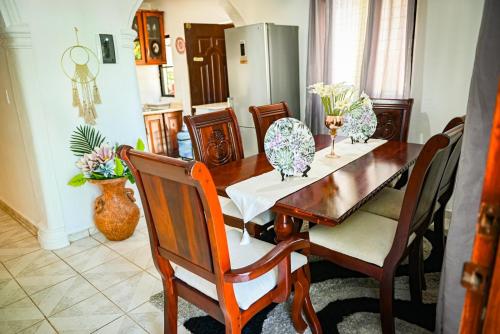 een eetkamer met een houten tafel en stoelen bij Lily House 3 in San Felipe de Puerto Plata