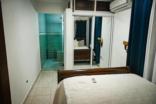 een slaapkamer met een bed en een inloopdouche bij Lily House 3 in San Felipe de Puerto Plata