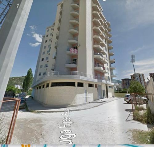 un grand immeuble d'appartements avec un parking dans l'établissement Apartament Kristi, à Vlorë