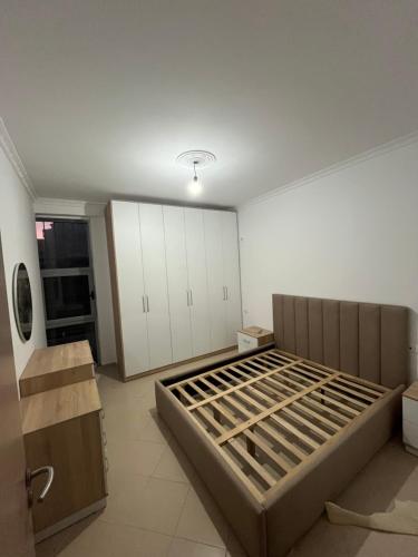 Cette grande chambre comprend un lit et des armoires blanches. dans l'établissement Apartament Kristi, à Vlorë