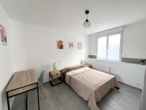 Dormitorio blanco con cama y mesa en 178B - Appartement T2 Tout Confort - Wifi Netflix, en Le Gond-Pontouvre