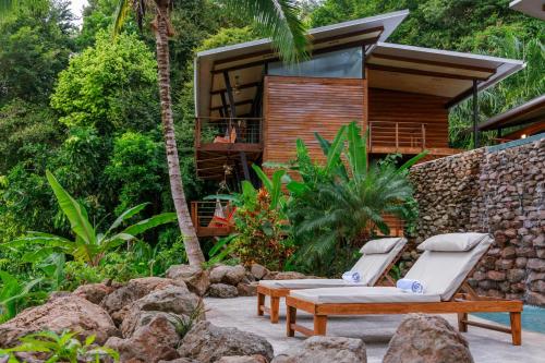 a resort with two lounge chairs and a house at The Resort at Isla Palenque Member of the Cayuga Collection in Boca Chica