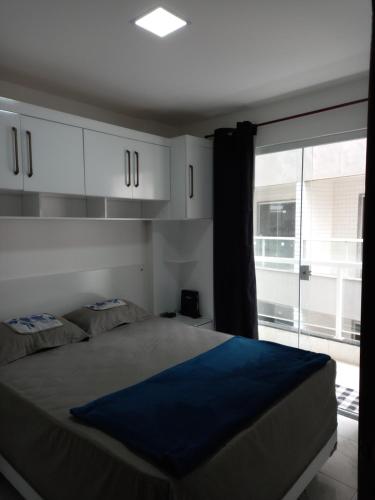 sypialnia z łóżkiem i dużym oknem w obiekcie Apartamento Recreio p12 w mieście Rio de Janeiro