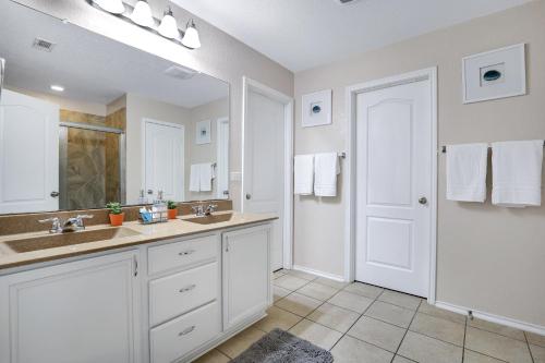 a white bathroom with two sinks and a mirror at Tranquility - A Birdy Vacation Rental in San Antonio