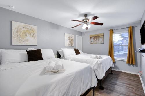 a bedroom with two beds and a ceiling fan at Tranquility - A Birdy Vacation Rental in San Antonio