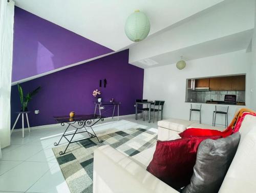 sala de estar con sofá y pared púrpura en Apartamento Oliveira House Rent en Praia