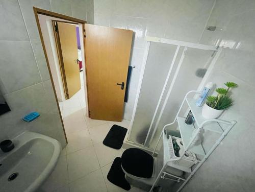 łazienka z umywalką, toaletą i drzwiami w obiekcie Apartamento Oliveira House Rent w mieście Praia