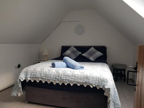 um quarto com uma cama com duas almofadas azuis em Beautiful 3-Bed House close to Ballybunion em Tralee