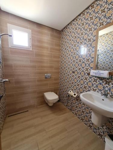 a bathroom with a toilet and a sink and a mirror at Musk de djerba suite aziz avec piscine in Temlale