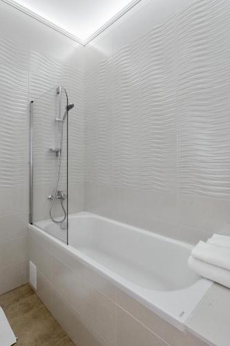 a white bathroom with a shower and a tub at Odesa Pearl Apartments in Odesa