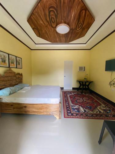 1 dormitorio con cama y techo de madera en Palm Garden Resort, en Carles