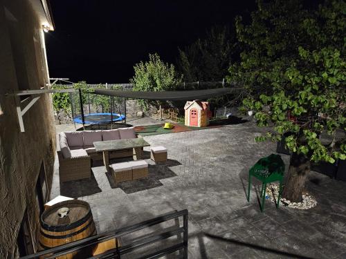 - une terrasse la nuit avec un canapé et une cabane pour chiens dans l'établissement La Casona de Simón, un pequeño paraíso urbano, à Camarma de Esteruelas