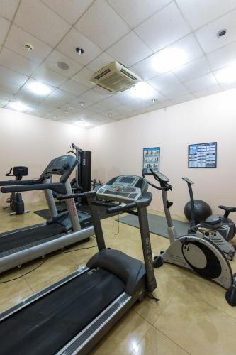 a gym with several tread machines in a room at Midindi Hotel in Accra