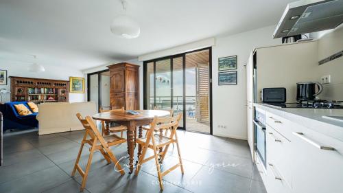 une cuisine et une salle à manger avec une table et des chaises dans l'établissement ROSEMARINE - APPARTEMENT CONCARNEAU VUE MER 2 adultes/2enfants, à Concarneau